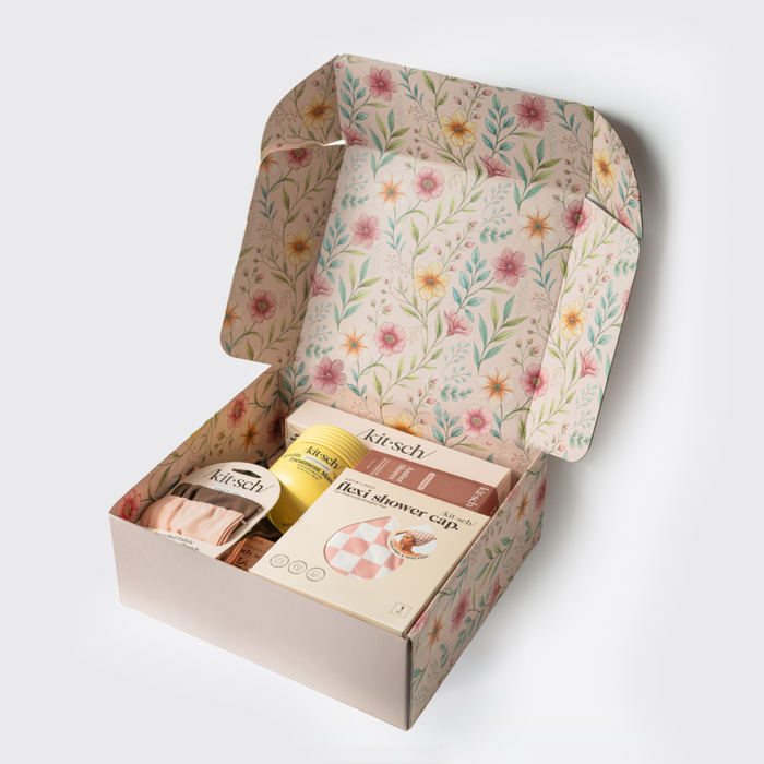 KITSCH Mother's Day Box open — showing watercolor floral-lined gift box interior with products nestled inside including Flexi Shower Cap, Treatment Mask, and hair accessories — premium Mother's Day gift set packaging