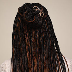 Woman with styled hair bun wearing a white sweater against a beige background