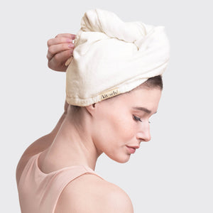 Model wrapping Kitsch Organic Bamboo Hair Towel around wet hair